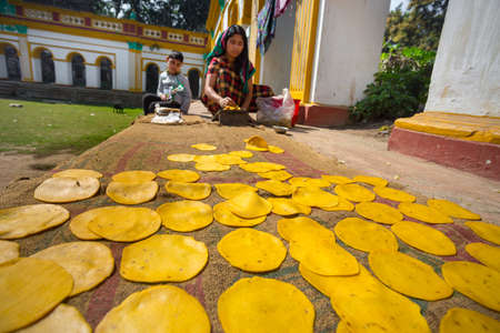 Bangladesh - March 02, 2019: An small business women making on handmade Pappor (Deep-fried Bread) at Dinajpur Palace, Dinajpur, Bangladesh.のeditorial素材