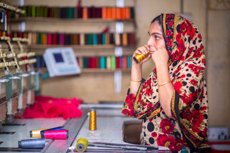 Bangladesh â August 6, 2019: A Bangladeshi woman garments worker working with Computerized Embroidery Machine at Madhabdi, Narsingdi, Bangladesh.のeditorial素材