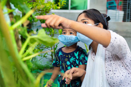 Little boy and mom wearing medical mask. A little boy and mom are traveling in the garden. Protect from the coronavirus infection on home quarantine.の写真素材