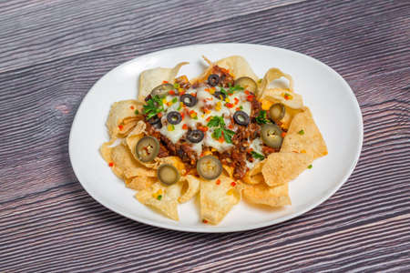 Mexican Famous Food Spicy Ground Beef Nachos. Heated crunchy tortilla chips with melted cheese and jalapeno served a snack food.の写真素材
