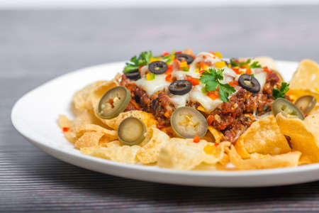 Mexican Famous Food Spicy Ground Beef Nachos. Heated crunchy tortilla chips with melted cheese and jalapeno served a snack food.の写真素材