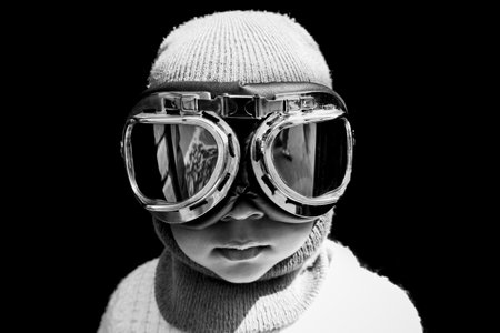 Portrait of a Asian boy pilot in vintage aviator helmet & goggles. Black and white vintage photograph.の写真素材