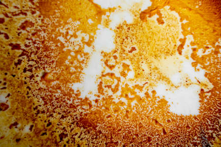 Abstract yellow-orange burning cream texture in white background. Milk burning pots orange-yellow texture. Abstract rustic texture.の写真素材