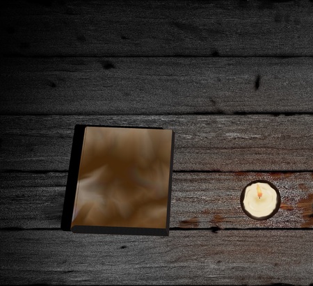 Book and burning candle on wooden planks. Drawingの写真素材