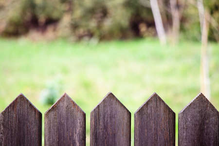 wood fence barrier in front of green nature backgroundの写真素材