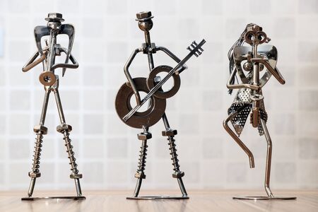 metal trinket musicians playing guitar and saxophone on the wooden tableの写真素材