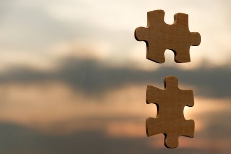 Putting puzzle pieces together on sky background with sunlight