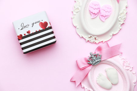 Beautiful pastel pink layout with stone decoration, notepad, bird hair pen, ribbon, hearts on pink blue background, top view, flat lay, border. Baby shower or Mothers Day greeting conceptの写真素材