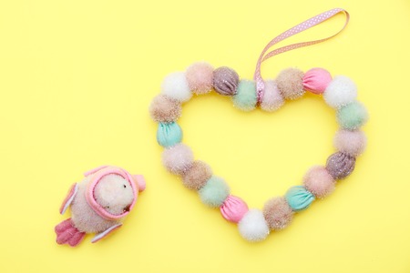 Heart symbol made of tassel fabric and leaves on flat lay background. Happy mothers and valentines day weddingの写真素材