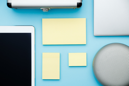 Overhead of office table with laptop, tablet pc and sticky notes, pencil. copy space blue flat layの写真素材