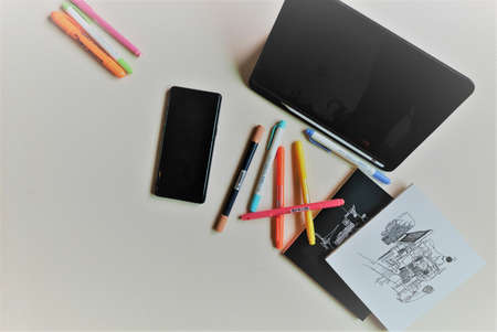 mobile phone with black bag, note book and colorful pens on white background.の写真素材
