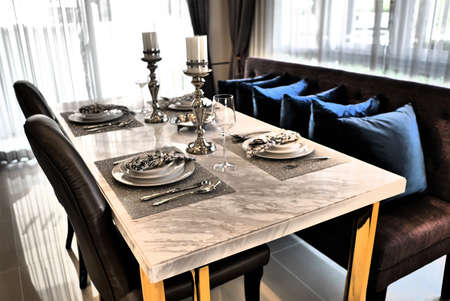 Food table provided for family members a dinner set with cutlery and knives placed on a shimmering...
