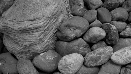 Grey  stones of various sizes and a large gray stone to compare the difference in the same place, ...