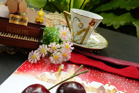 The atmosphere of Christmas preparation consists of a piano, a coffee cup, flowers and a Christmas...