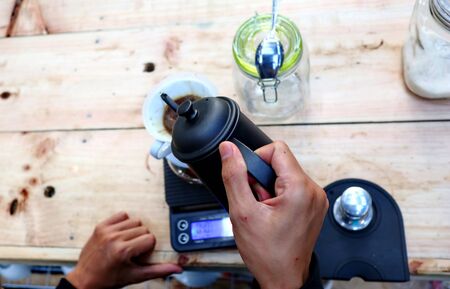coffee brewing, step by step. Barista gently pours hot water on the surface of the ground coffee. Wetting the coffeeの写真素材