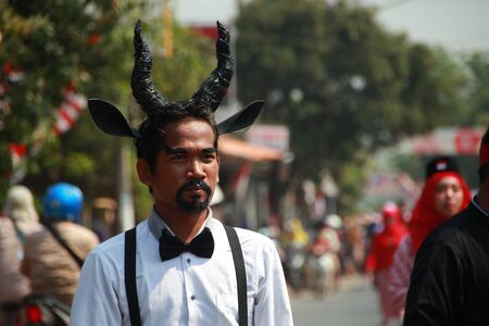 A man has a black horn on his head, walking on an event, Batang Central Java Indonesia, 19 August 2019, Batang  Central Java Indonesia, 19 August 2019のeditorial素材