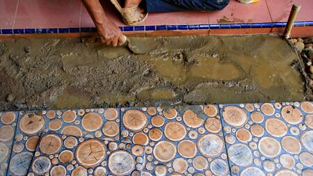 Documentation of construction workers when installing ceramic tiles for floors, selectively focusing and bluring objects and not focusingの写真素材
