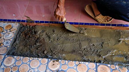 Documentation of construction workers when installing ceramic tiles for floors, selectively focusing and bluring objects and not focusingの写真素材