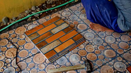 Documentation of construction workers when installing ceramic tiles for floors, selectively focusing and bluring objects and not focusingの写真素材