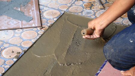 Documentation of construction workers when installing ceramic tiles for floors, selectively focusing and bluring objects and not focusingの写真素材