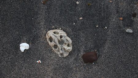 the rocks on the beach sand are gray in the morning, with less light, out of focus, suitable for the backgroundの写真素材