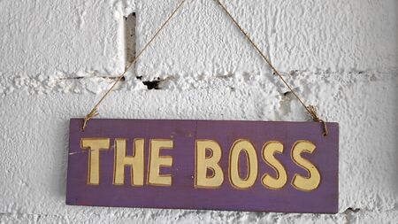 The words `THE BOSS` on the wooden boards are posted on the white wallsの写真素材