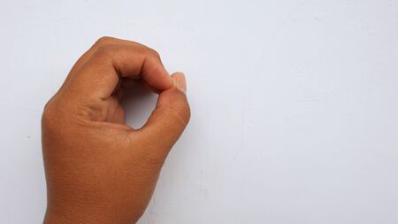 left hand photographed with the meaning of a symbol and white background, not in focus. blurry