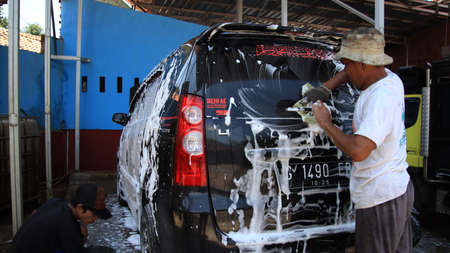 worker car cleaning, spraying and wiping, at his workplace, Batang, February 27, 2021のeditorial素材