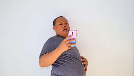 Asian man with bald hair is on the phone, with an old telephone with strange expression