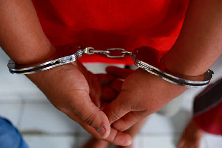 Man handcuffed hands. Prisoner or arrested. close-up of hands in handcuffs, selective focus. Close...