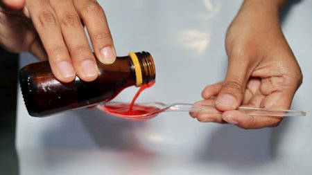 Treatment and medicine concept - bottle of medication or antipyretic syrup and spoon, Cough and Cold medicineの写真素材