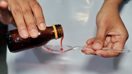 Treatment and medicine concept - bottle of medication or antipyretic syrup and spoon, Cough and Cold medicineの写真素材