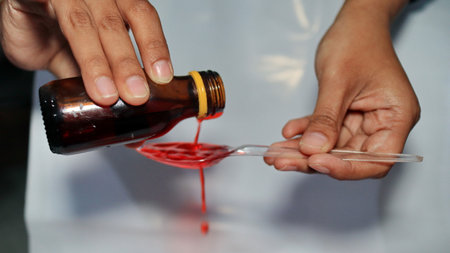 Treatment and medicine concept - bottle of medication or antipyretic syrup and spoon, Cough and Cold medicineの写真素材