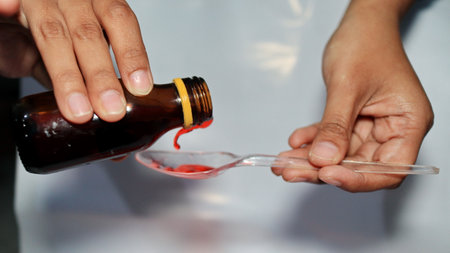 Treatment and medicine concept - bottle of medication or antipyretic syrup and spoon, Cough and Cold medicineの写真素材