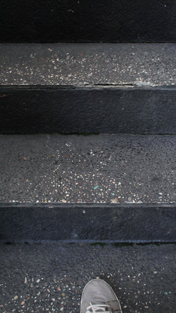 one foot steps on the stairs with the black floor