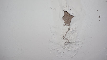 cracked concrete wall covered with gray cement surface as backgroundの写真素材