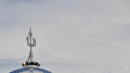 The God letter sign on the top of mosque dome roof top with the sky in the background