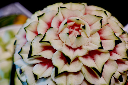 A carving of a watermelon, with the skin and flesh meticulously shaped to resemble a blooming flower.の写真素材