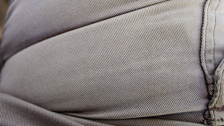 Close up image of light gray woven fabric with smooth texture, natural folds, and soft shadows, creating a minimalist textile background for modern design projects.の写真素材