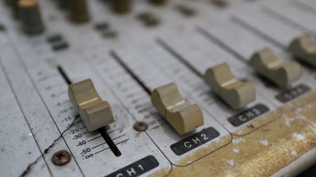Detailed shot of old, dirty faders on a professional audio mixing console. Captures the worn...