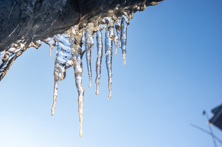 Icicles hanging from the roof close upの写真素材