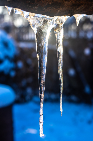 Icicles hanging from the roof close upの写真素材
