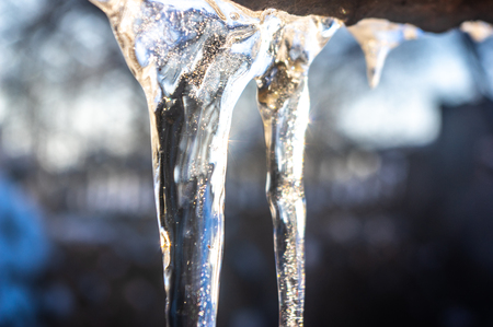 Icicles hanging from the roof close upの写真素材