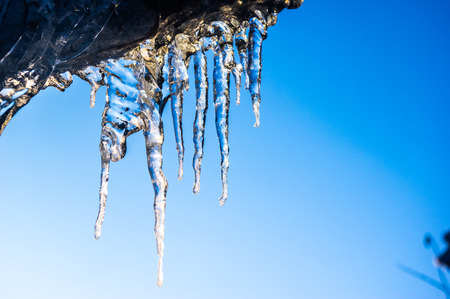 Icicles hanging from the roof close upの写真素材