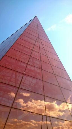 Office building close up. Bottom view of modern skyscrapers in business district against blue sky.