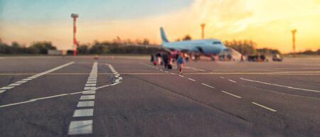 Tourist passager getting in to airplane at airport, walking from the terminal to the plane.の写真素材