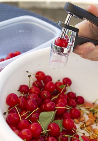 Pitting Sour Cherries in a bowlの写真素材