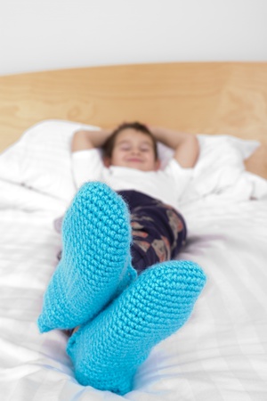 Seven yers old kid cozy wearing his knitted winter socks proudly. Ready for winter.の写真素材