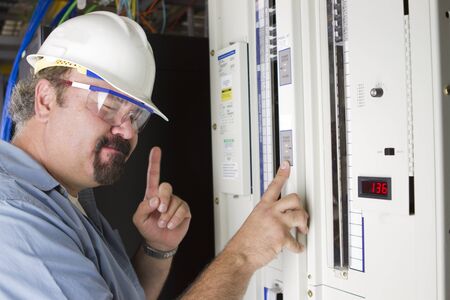 An engineer try to remember the volage levels infront of a power panel, one minute, donの写真素材