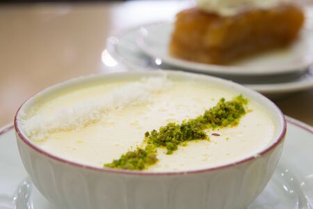 Traditional Turkish dessert Sutlac made with milk, rice and flour, served with pistachio and coconut crumbles.の写真素材